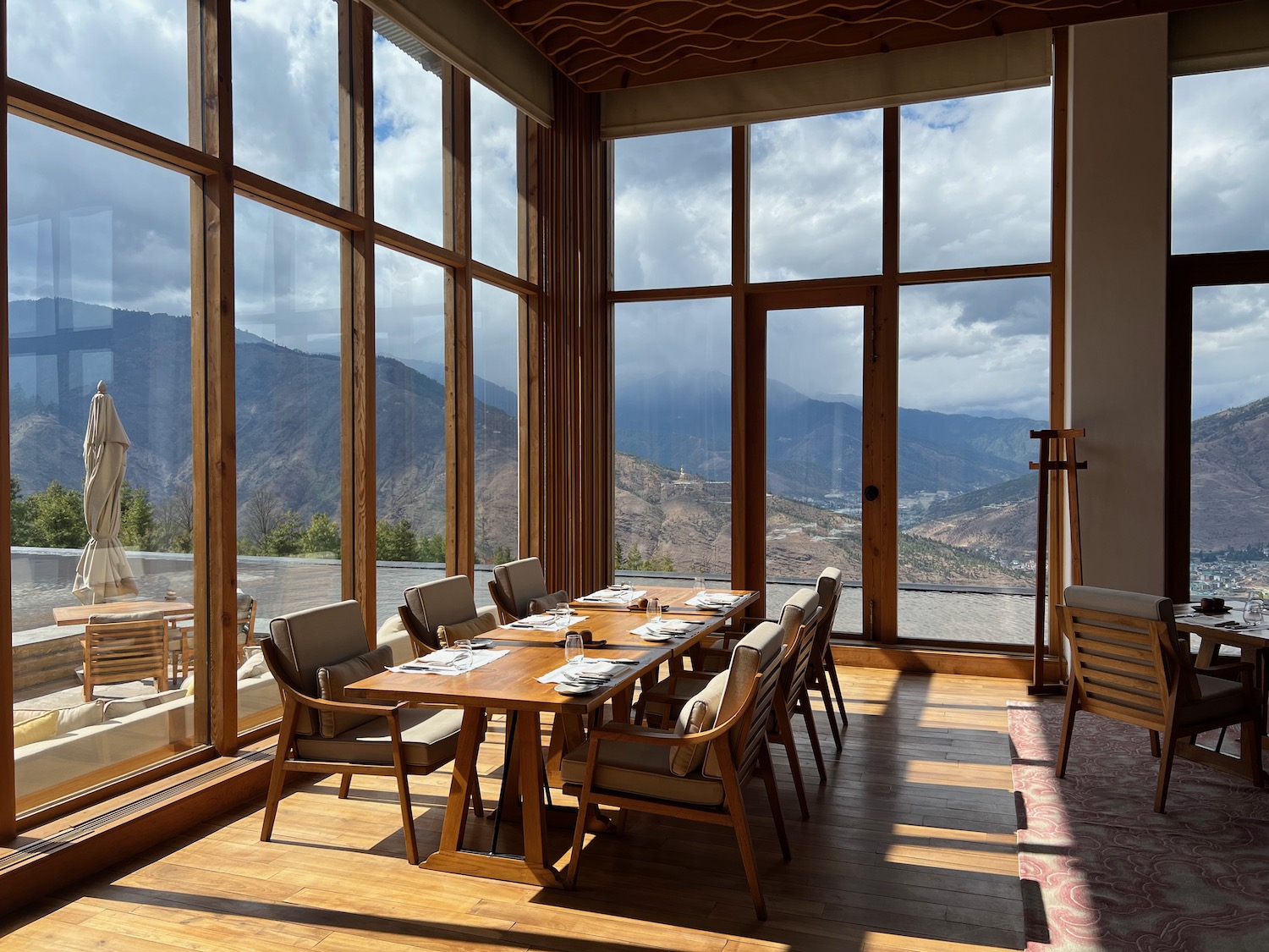 a room with a table and chairs and a view of mountains