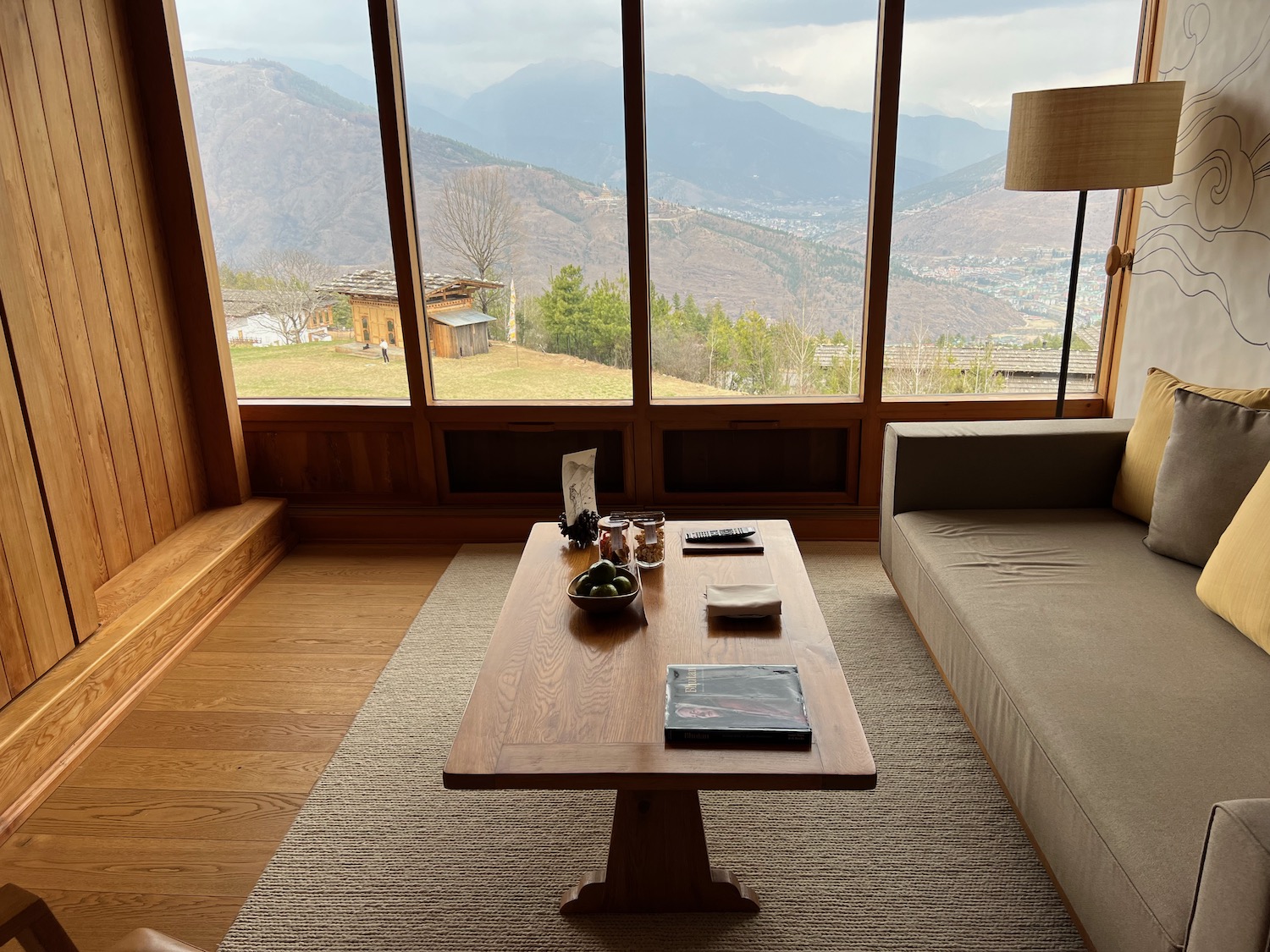 a coffee table in a room with a couch and a large window