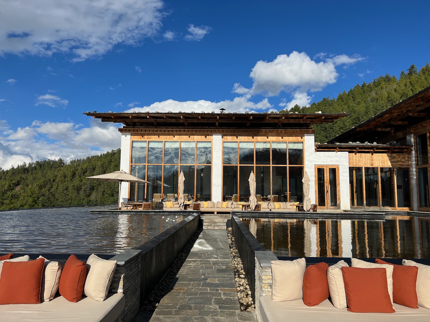 a building with a body of water and a dock with pillows