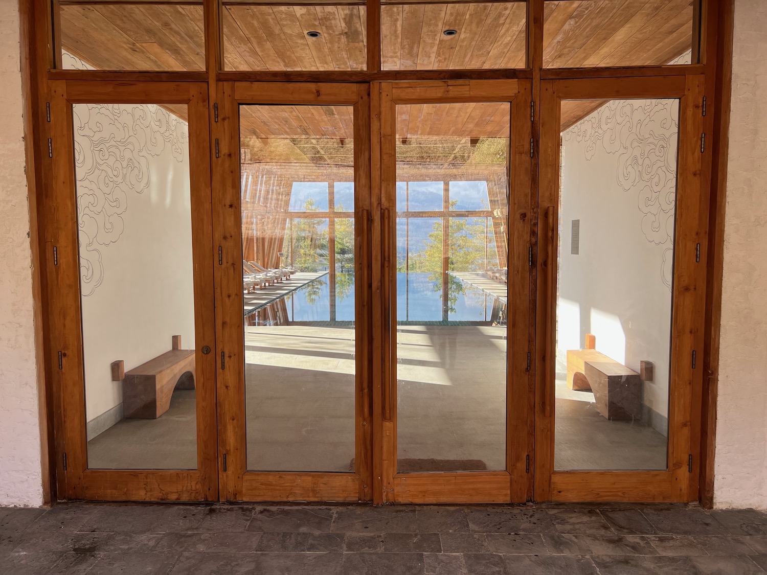 a glass doors with a view of a pool and a deck