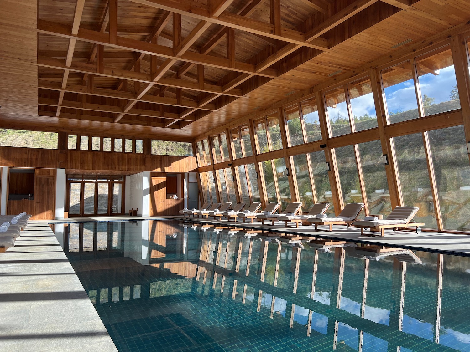 a pool with chairs and a large window