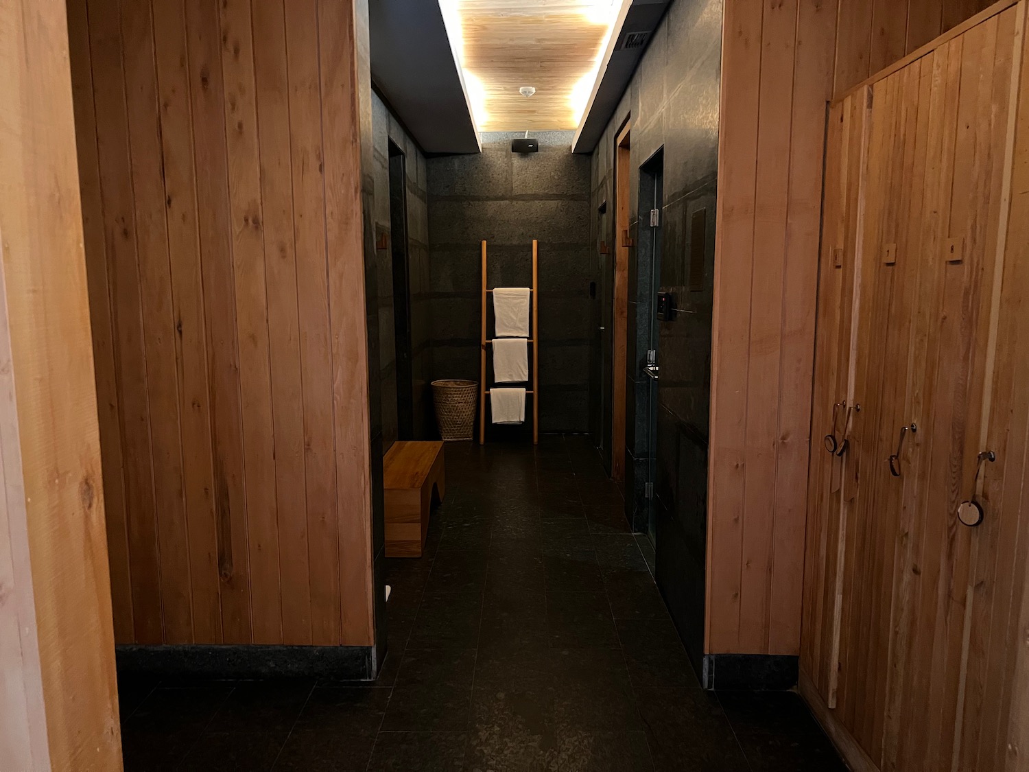 a hallway with wood walls and a shelf