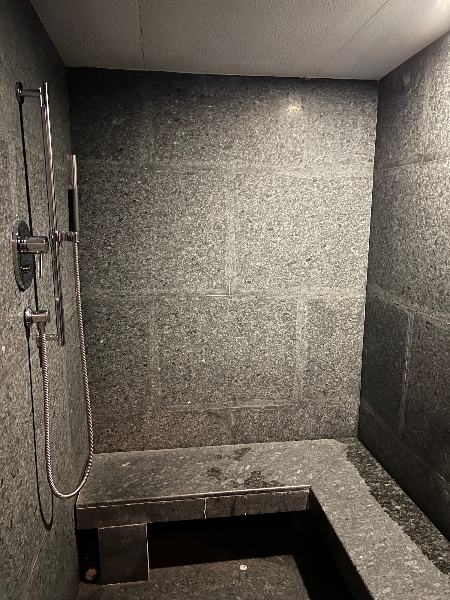 a shower with a stone bench