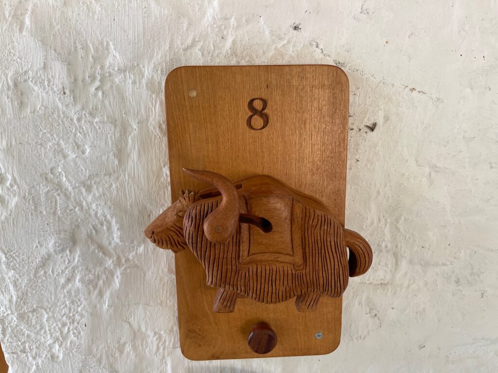 a wooden wall mounted object with a bull carved into it