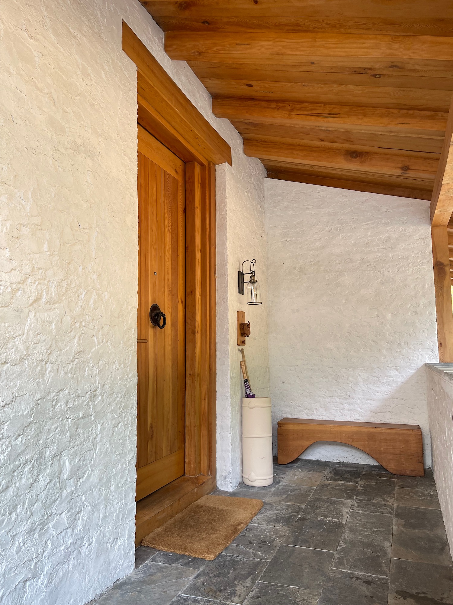 a wooden door and bench in a white house