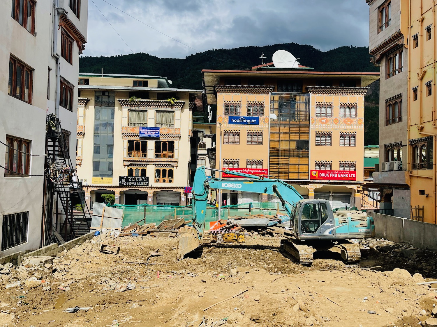 a construction site with a crane and buildings in the background