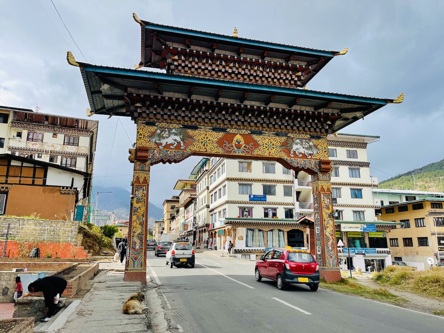 a large archway with a roof over a street with buildings