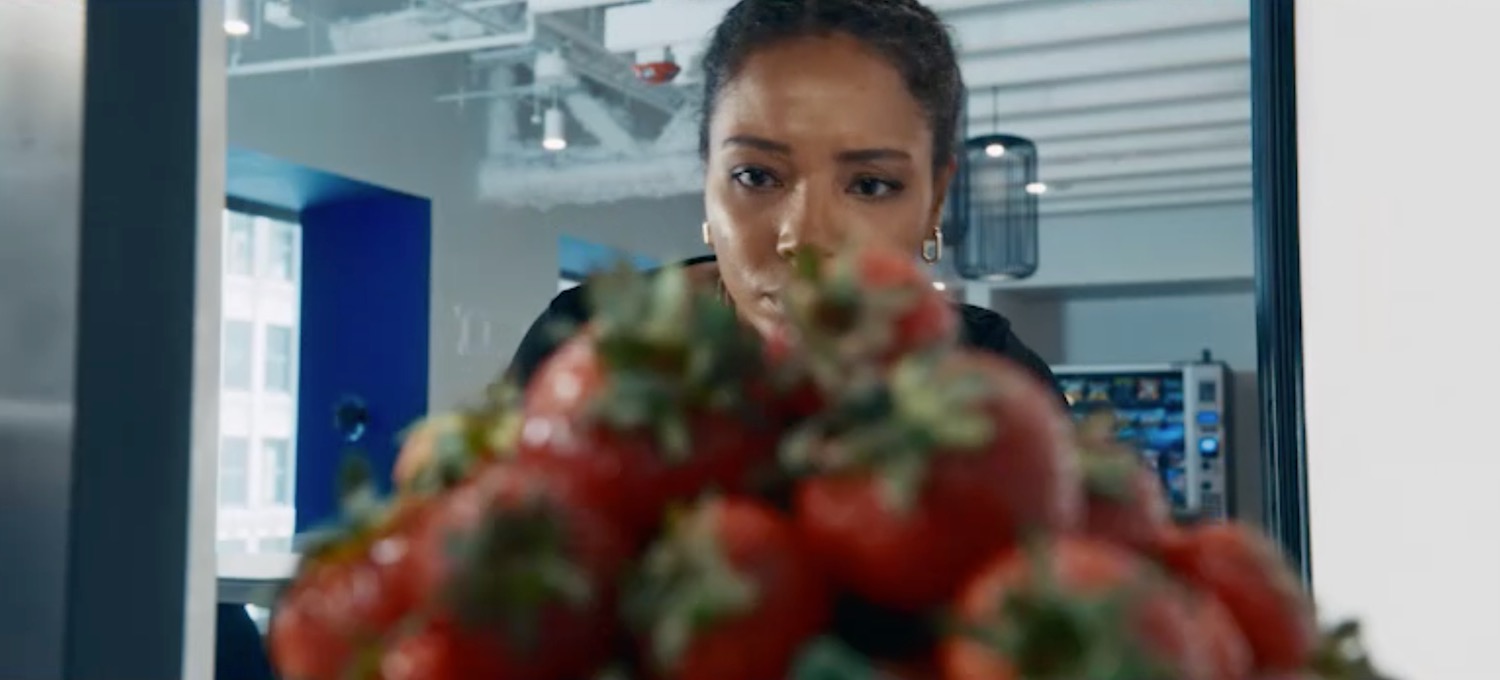 a woman looking at a pile of strawberries