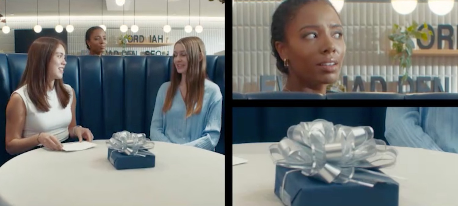 a woman sitting at a table with a gift