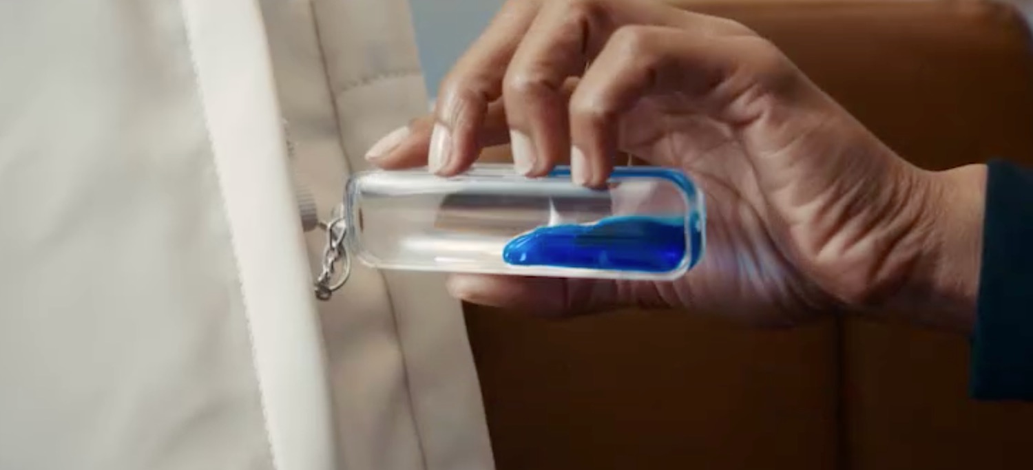 a hand holding a bottle with blue liquid