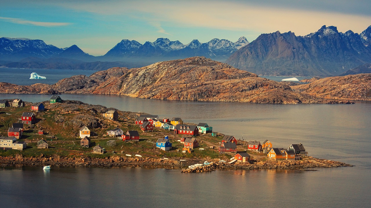 a small island with houses and mountains in the background