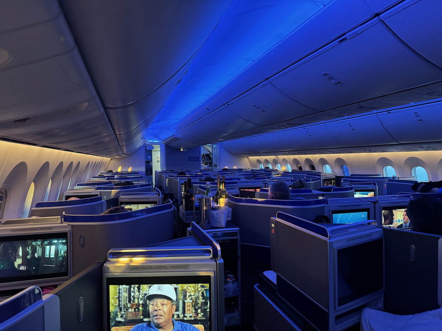 a row of seats with monitors on the side of the plane