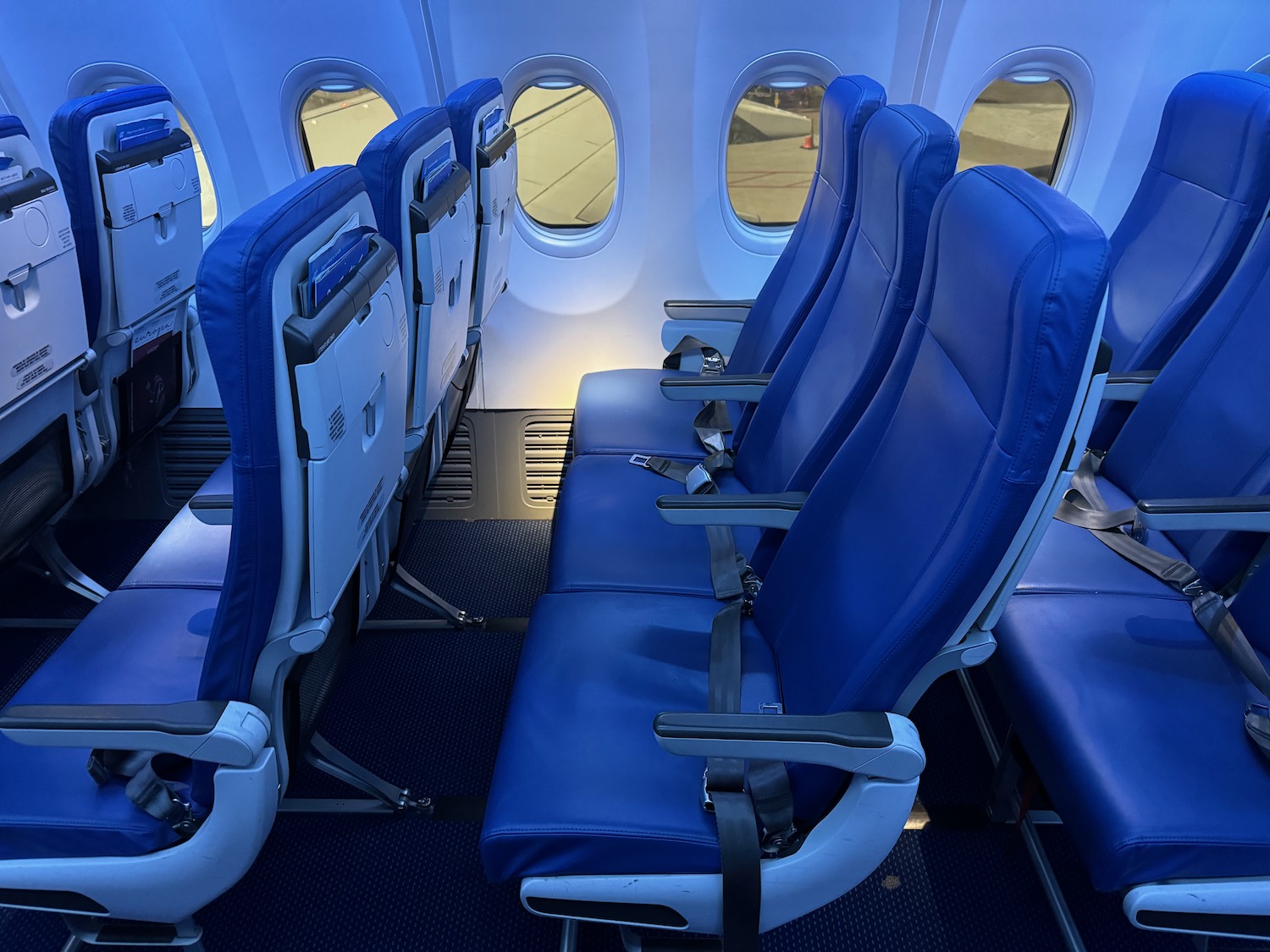 a row of blue seats on an airplane