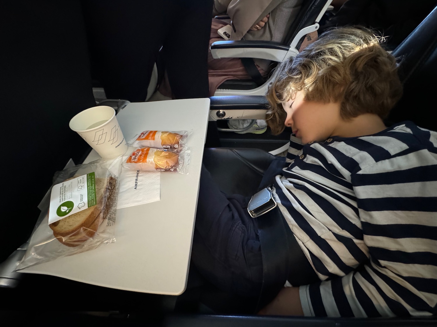 a boy sleeping on a table with food on it