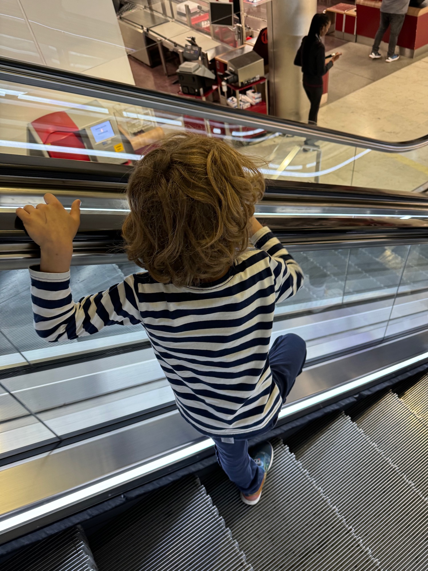 a child climbing up an escalator