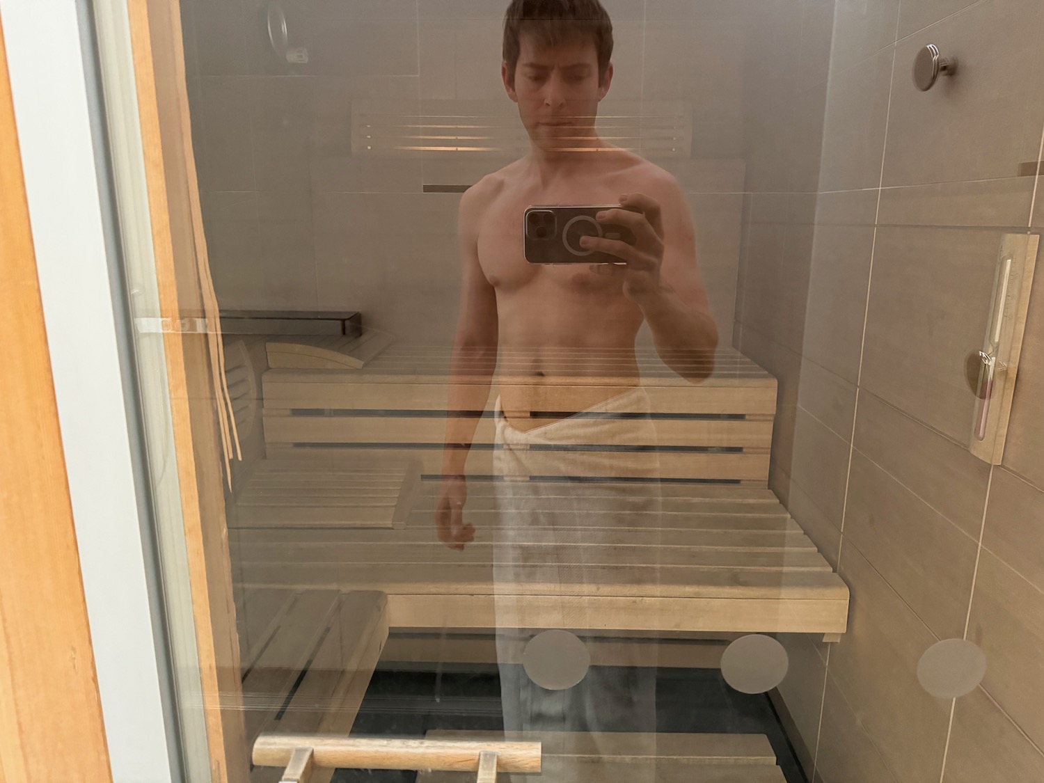 a man taking a selfie in a sauna