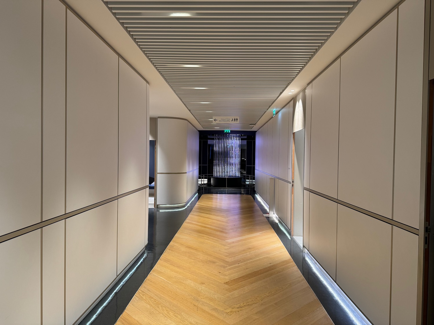 a hallway with white walls and a wood floor