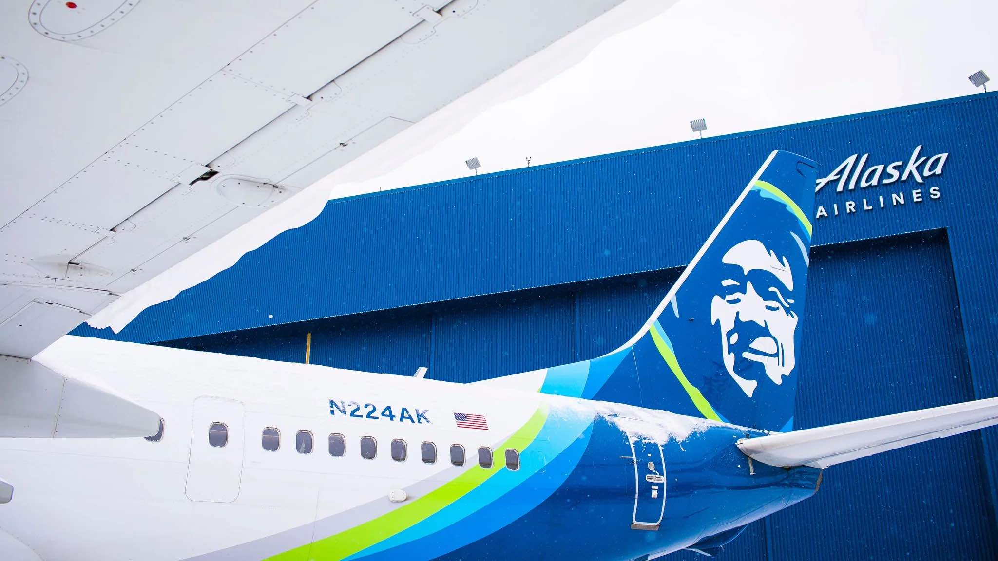 a blue and green airplane with a face on the tail