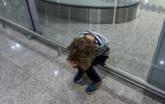 a boy sitting on a floor with his head in his hands