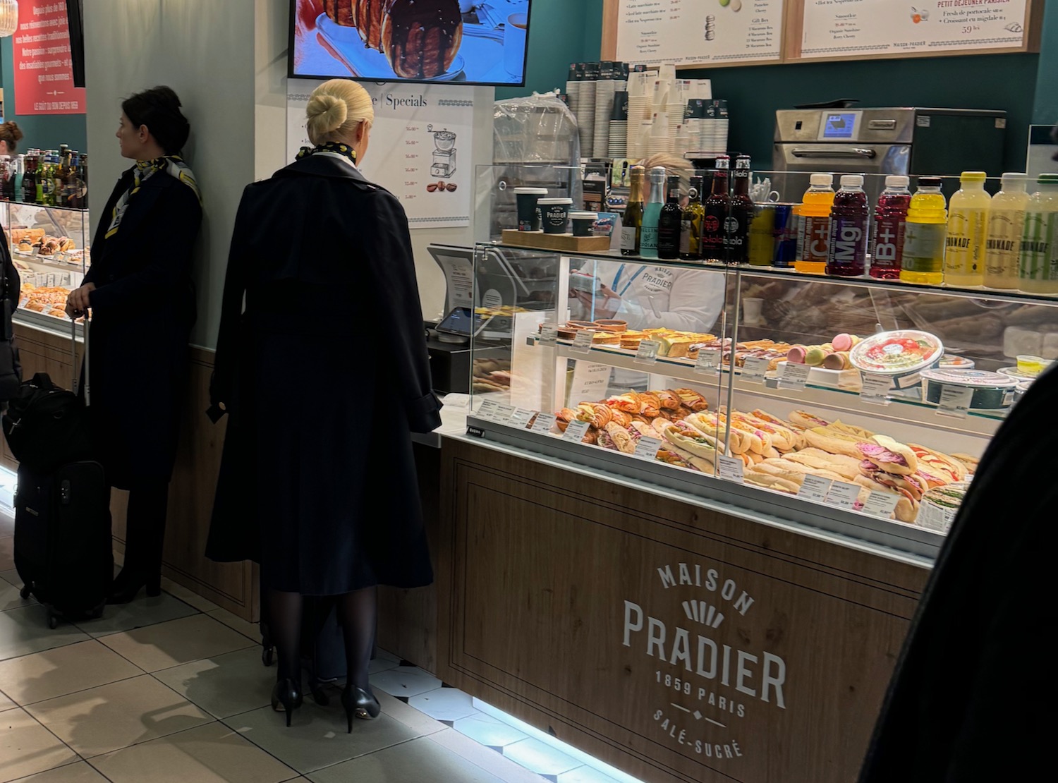 a woman standing in front of a display case with food