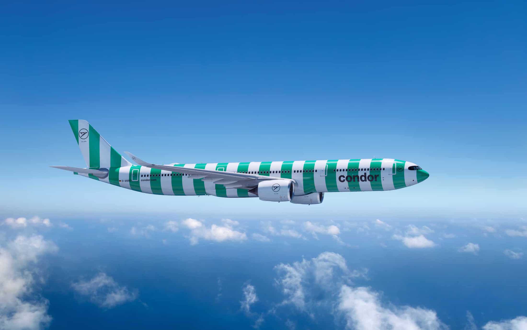 a green and white striped airplane flying in the sky