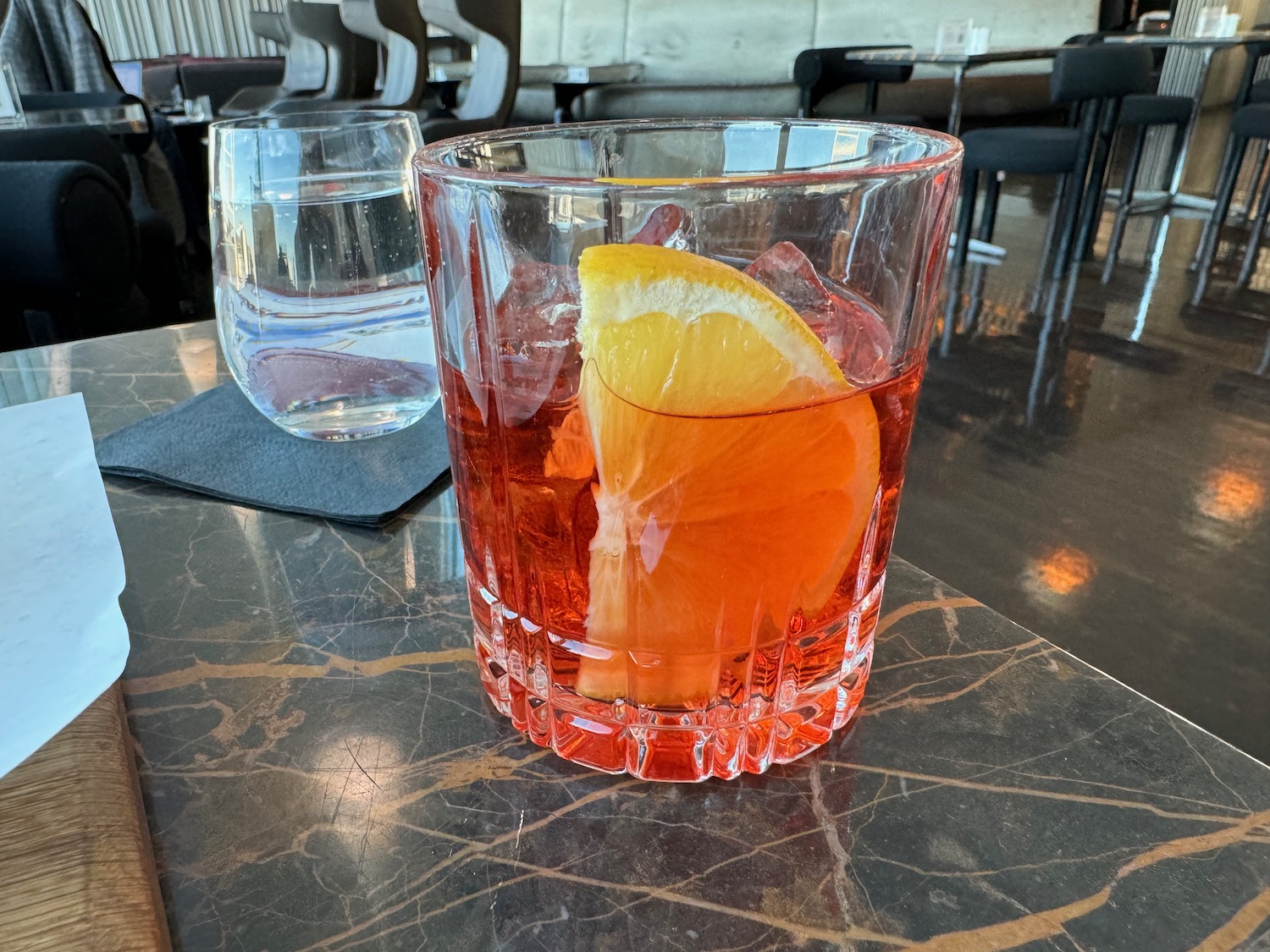 a glass with a drink and a slice of orange on it