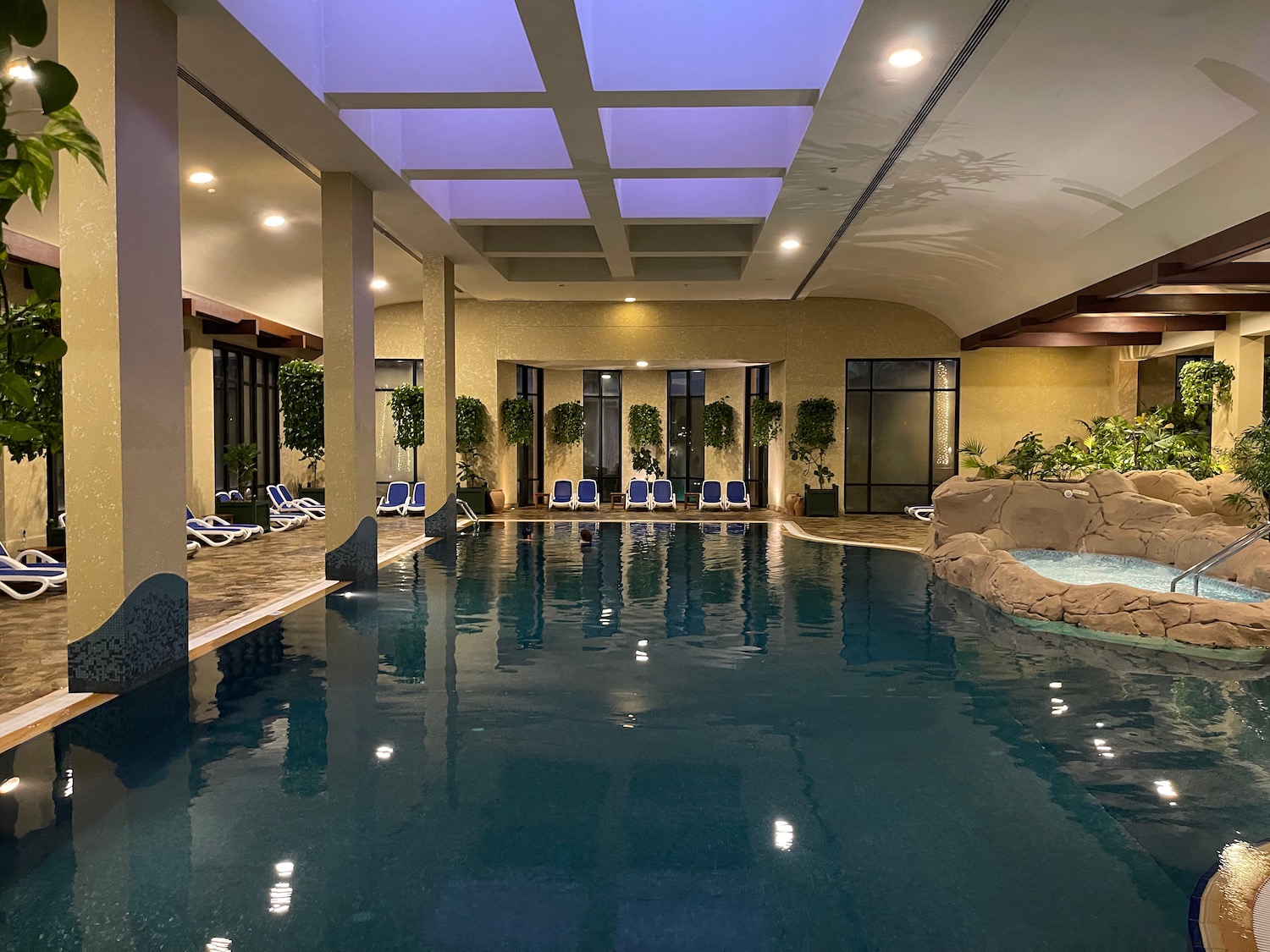 a indoor swimming pool with a large rock wall and a large pool