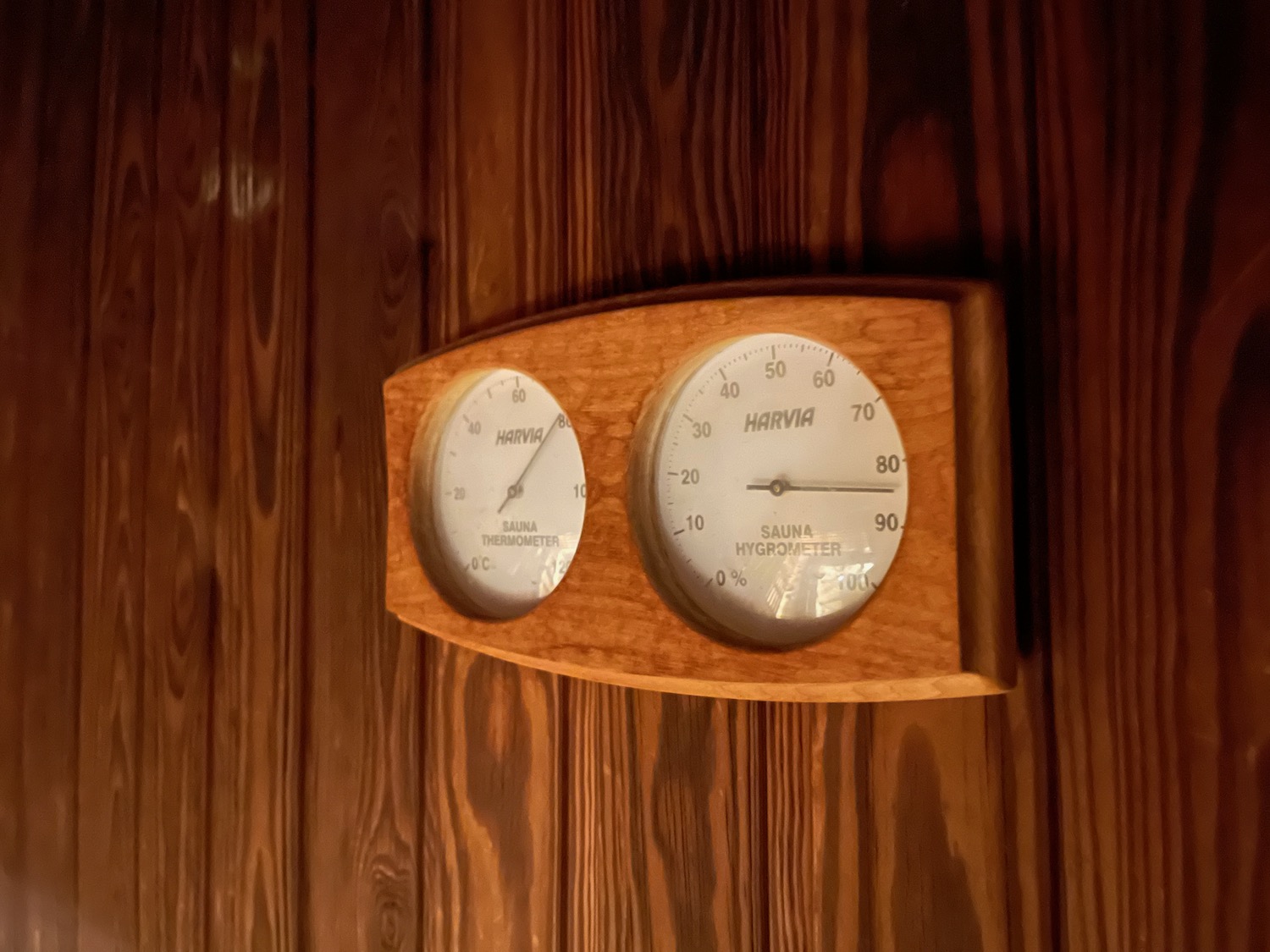 a wooden thermometer and hygrometer on a wood surface