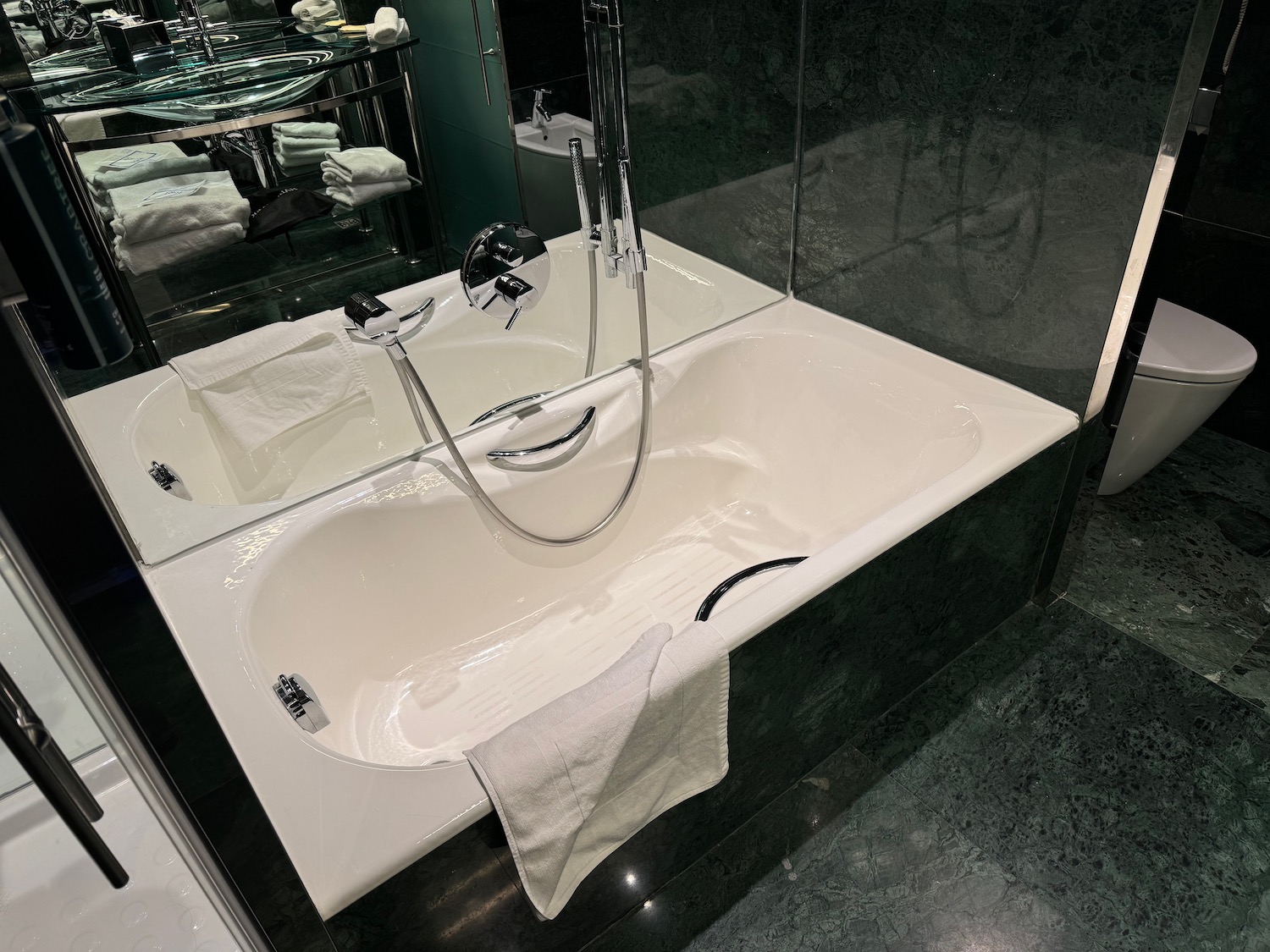 a bathtub with a shower head and a towel