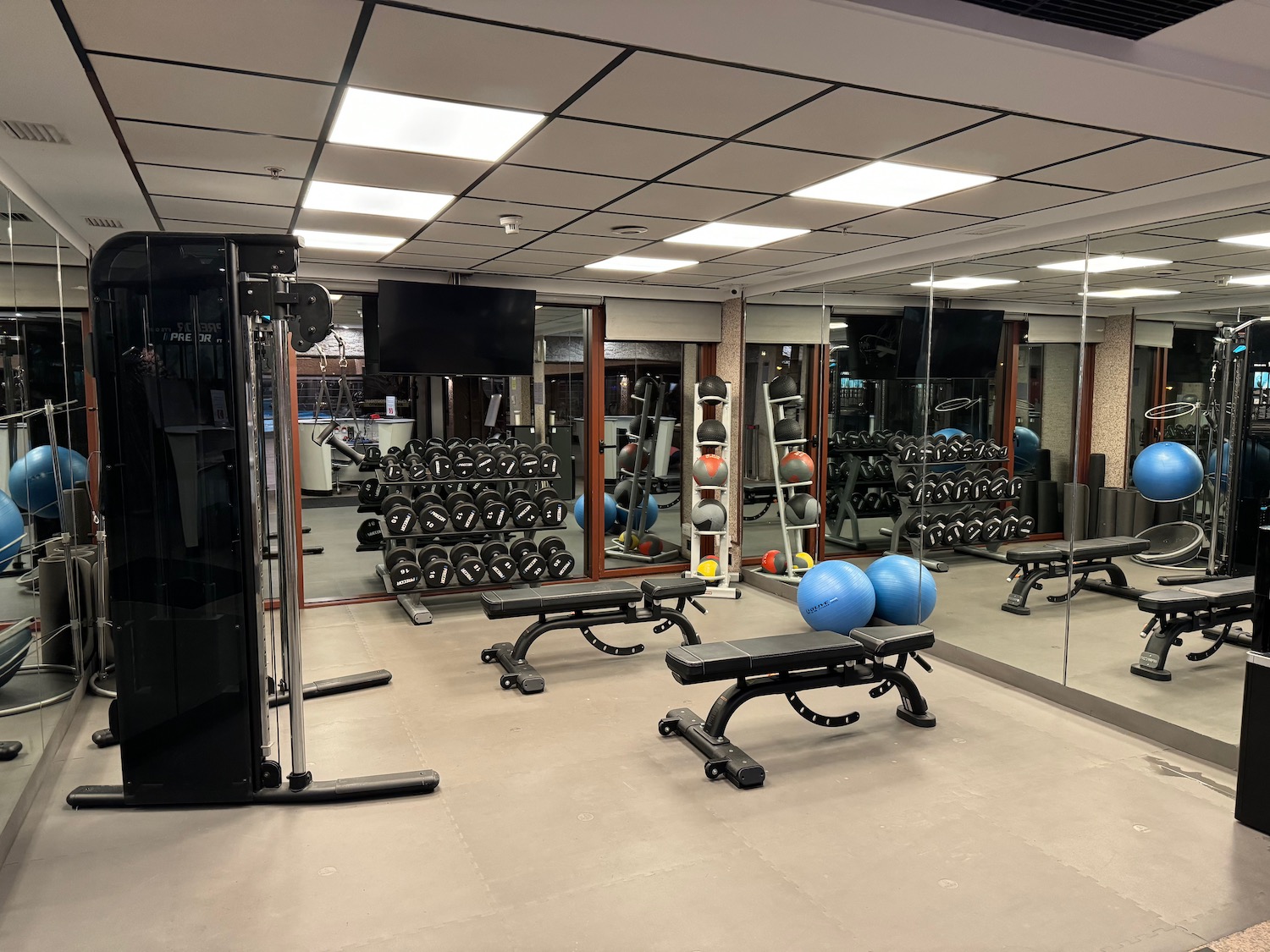 a mirror room with weights and a bench