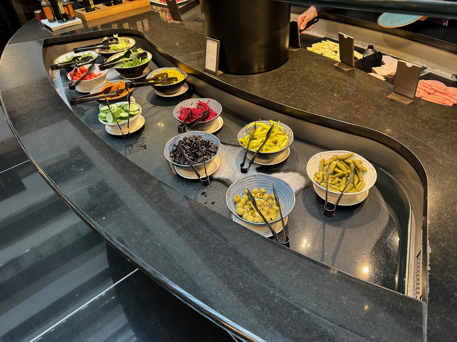 a row of bowls of food on a counter