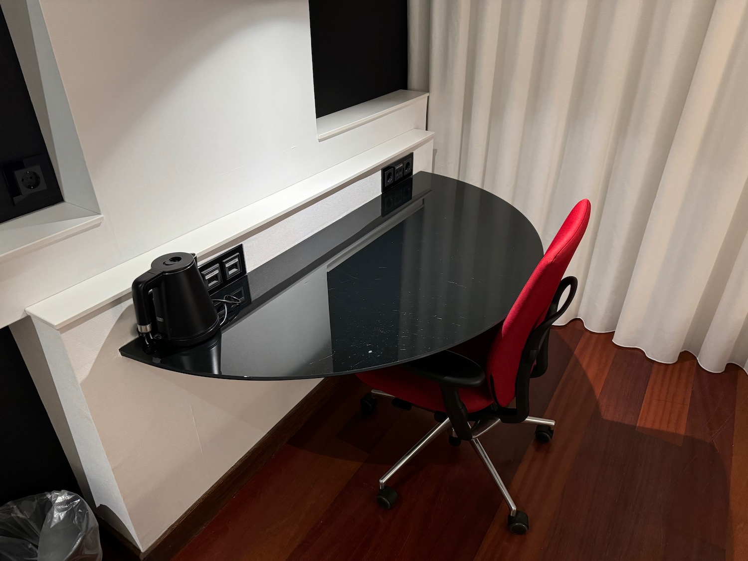 a black table with a red chair in a room