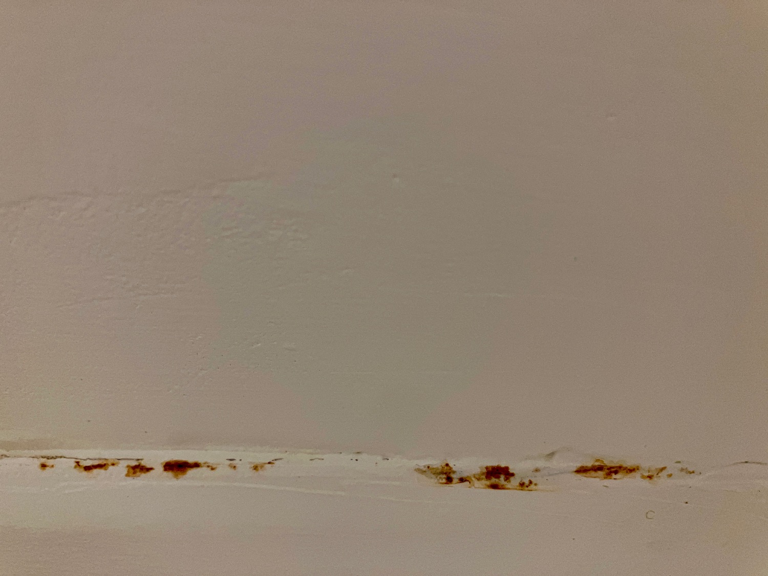 a white wall with brown spots