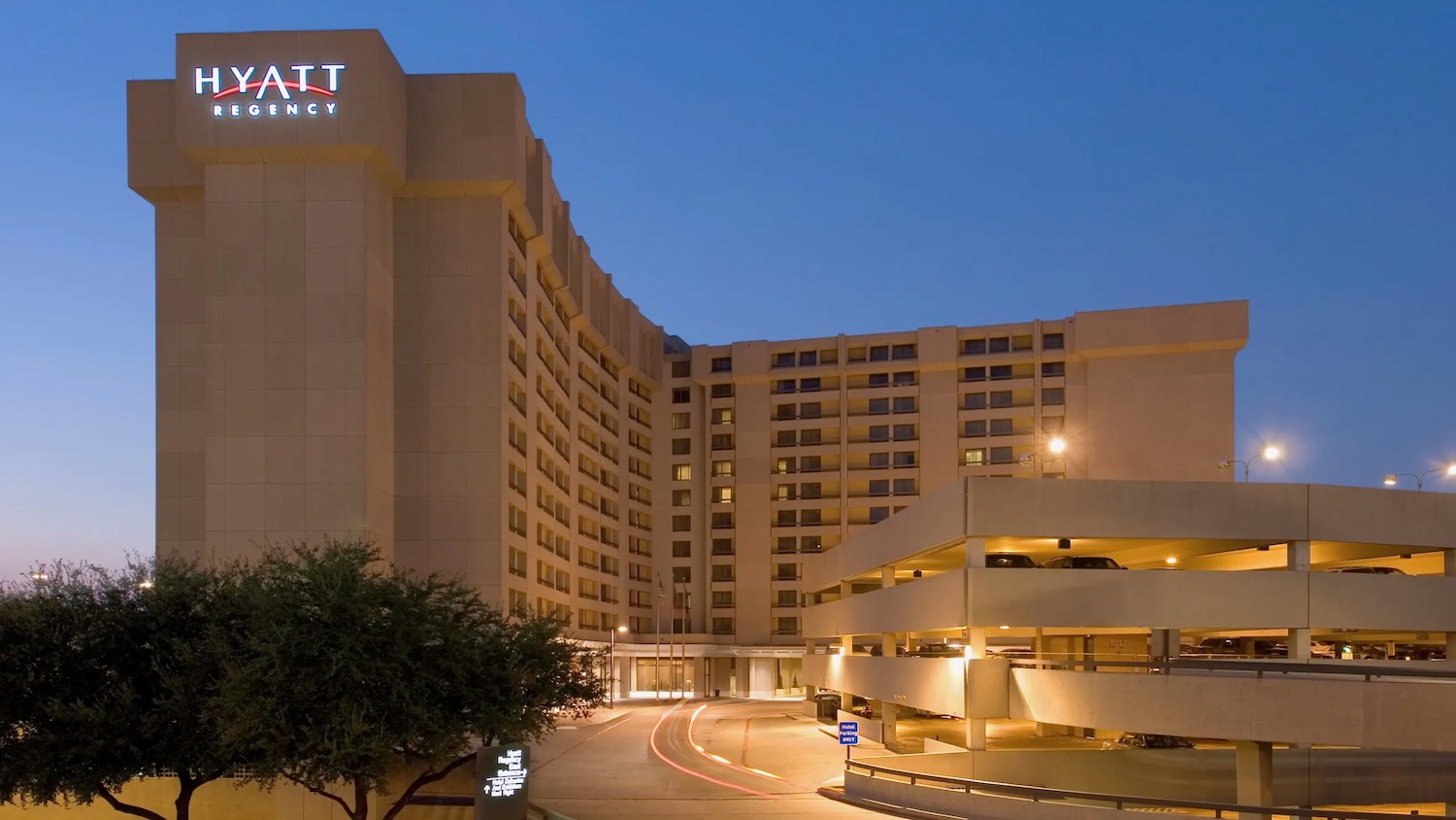 a large building with parking garage and parking lot