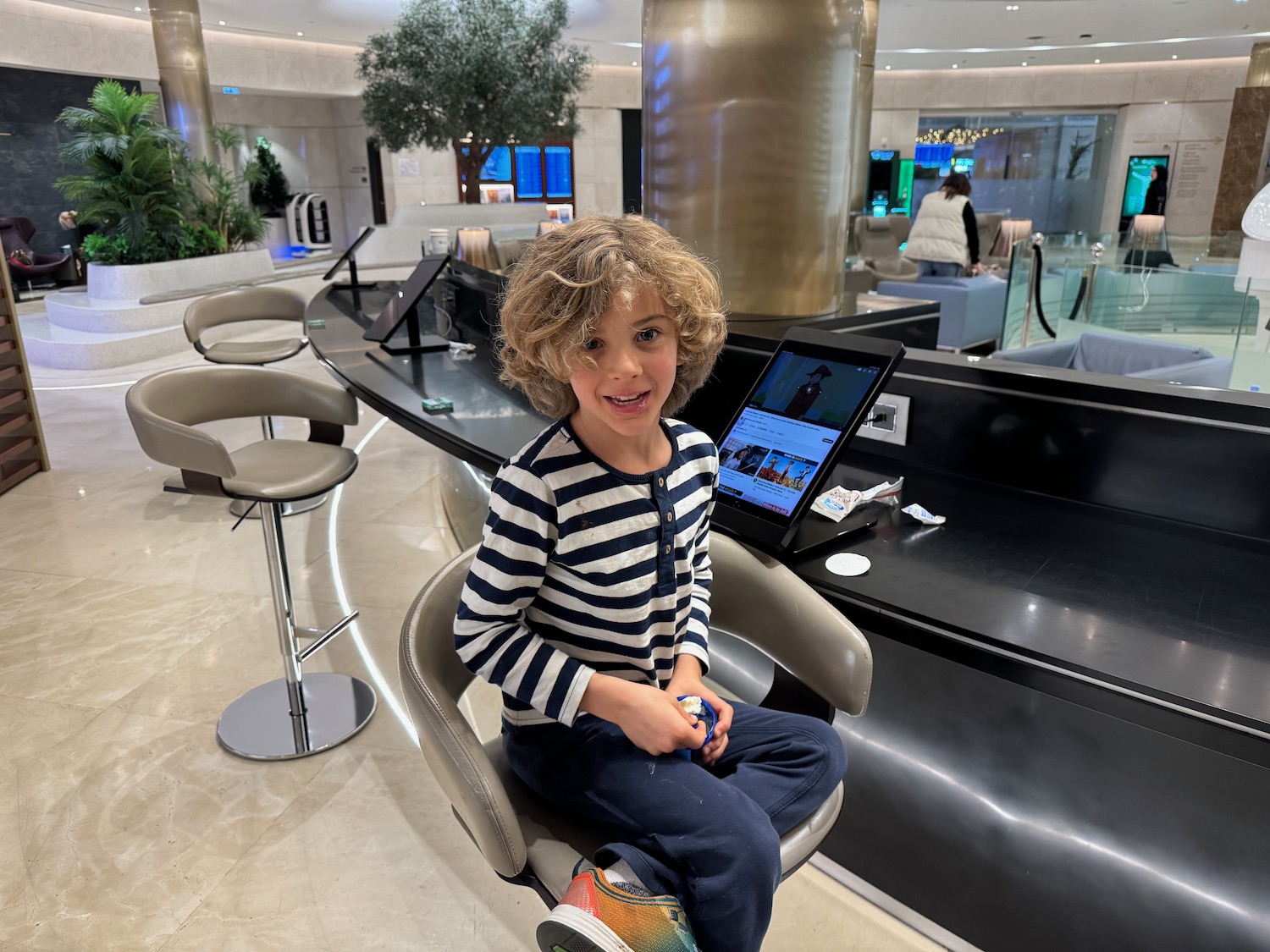 a boy sitting in a chair with a laptop