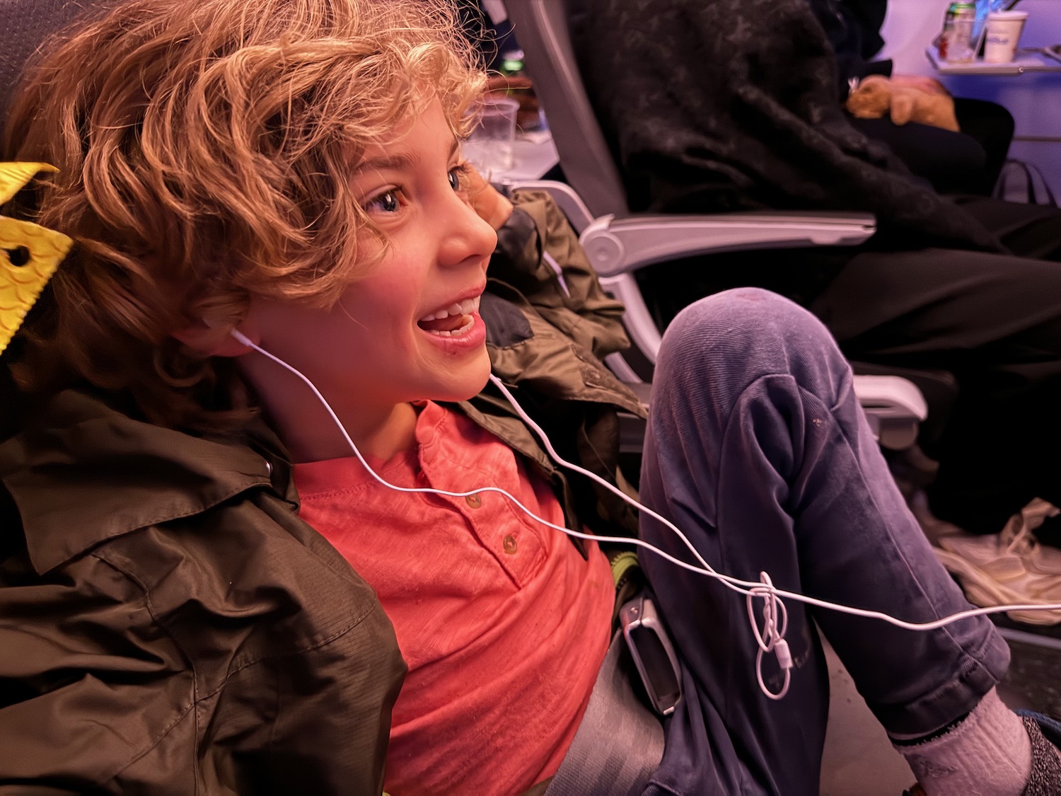 a boy sitting in an airplane with earphones