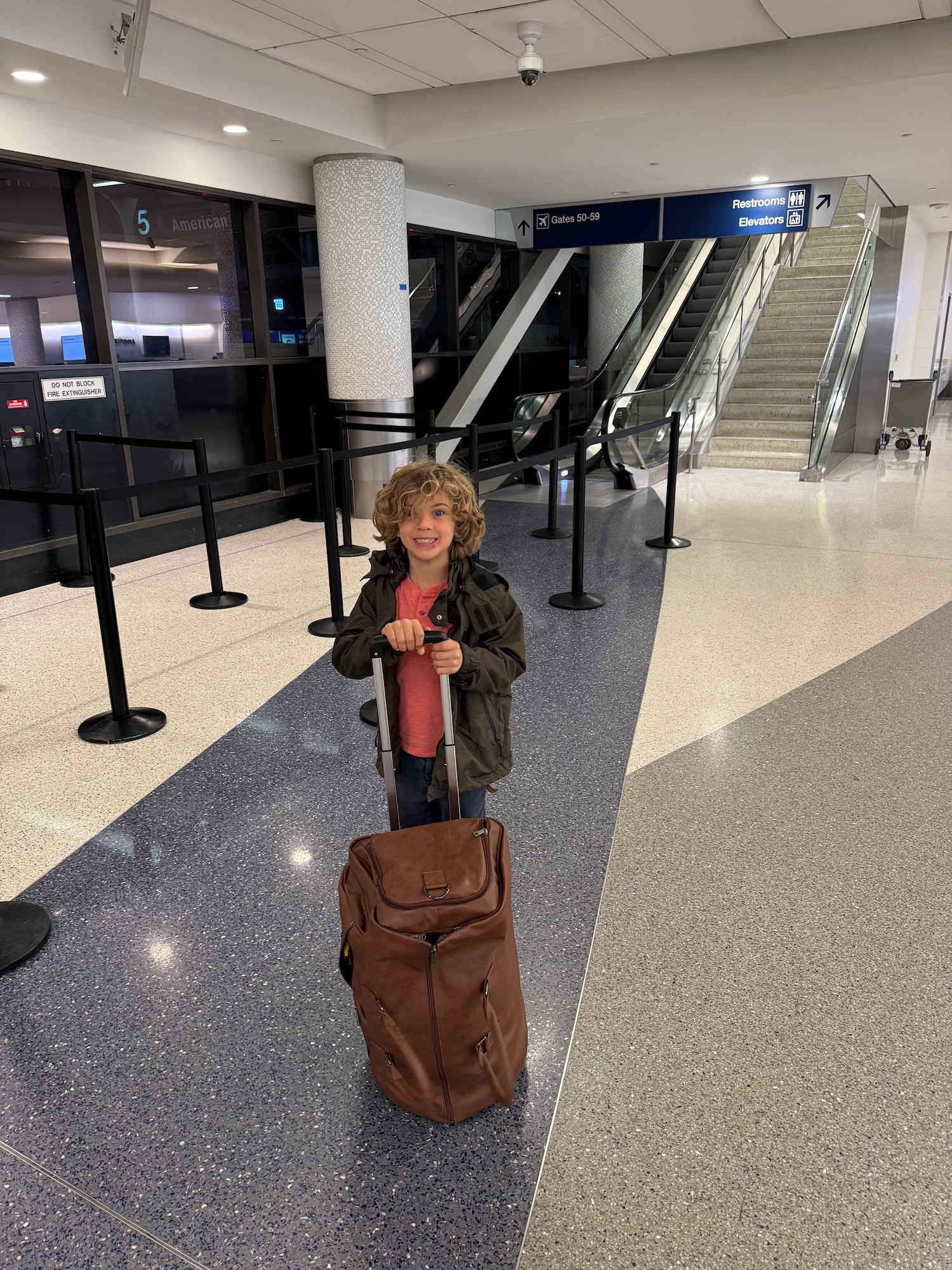 a child with a brown suitcase in a building