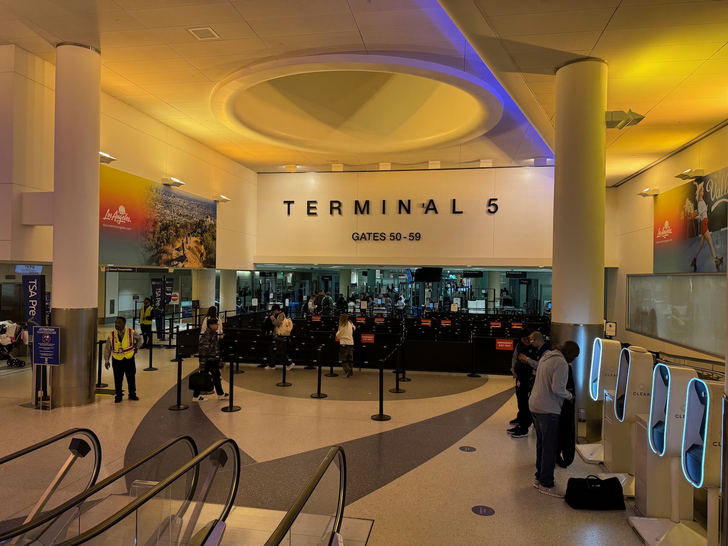 people in a terminal with people standing in front of a sign