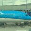 a blue and white airplane at an airport