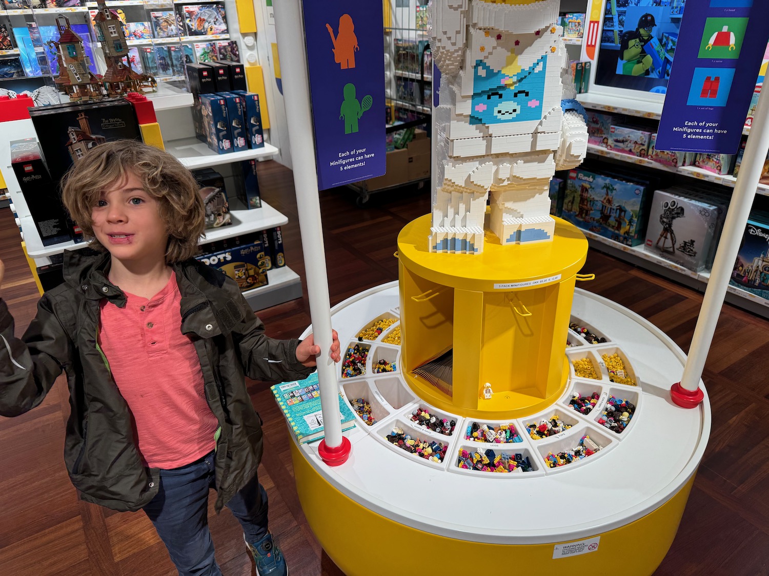 a child standing next to a large yellow and white building block