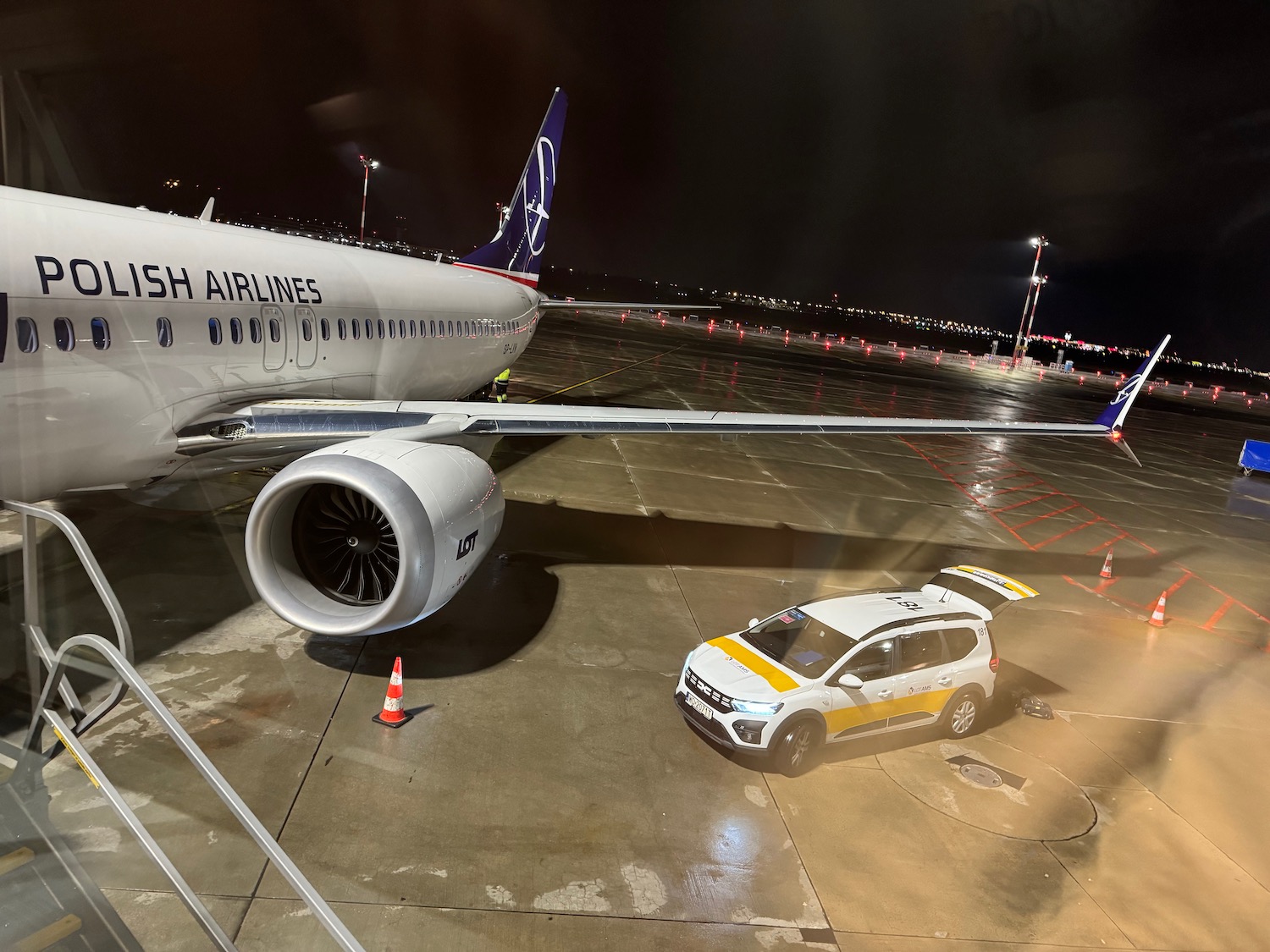 a white car parked on a tarmac at night