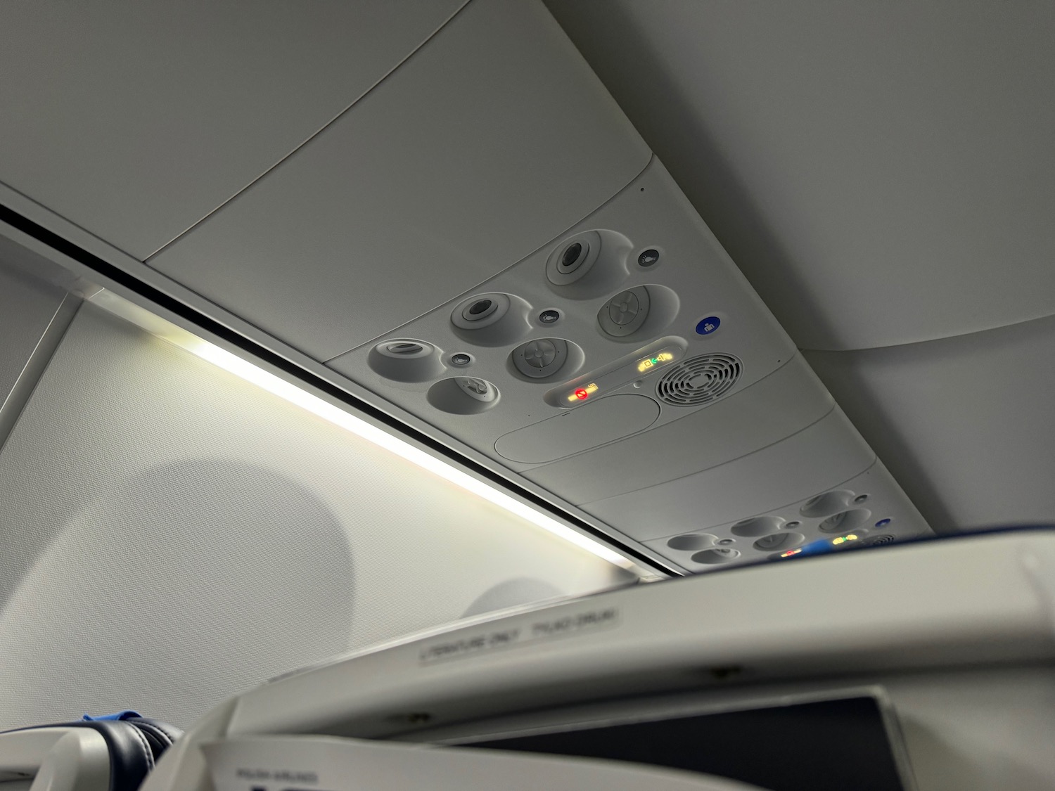 a white panel with lights and buttons on the ceiling