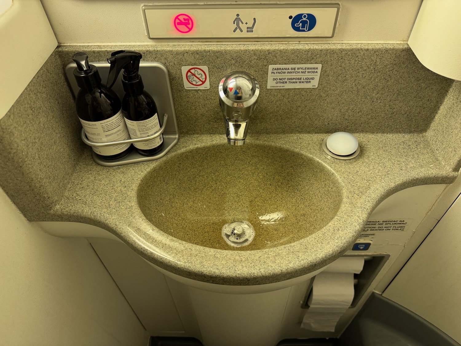 a sink with a faucet and bottles on it