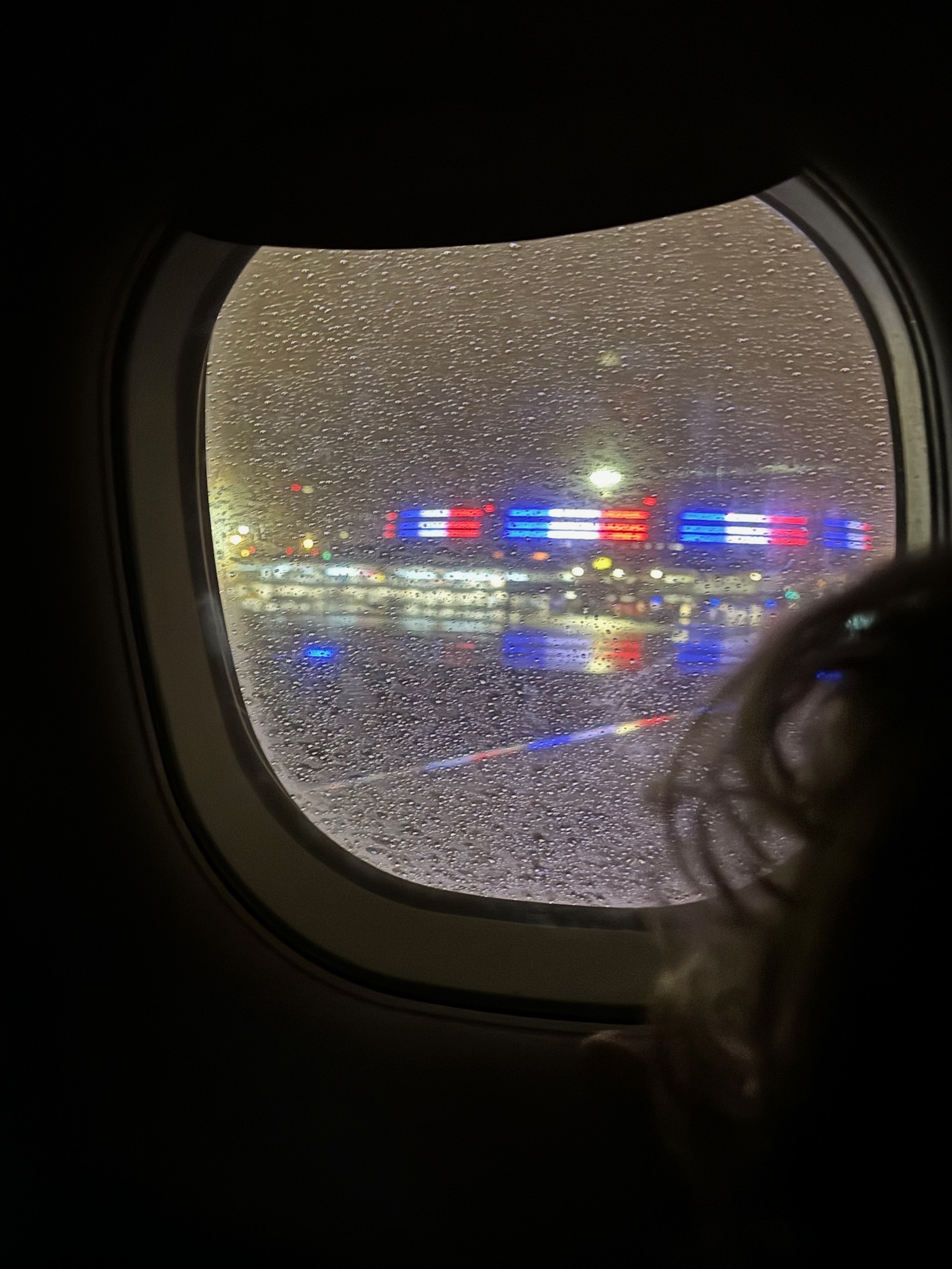 a window of an airplane with rain on it