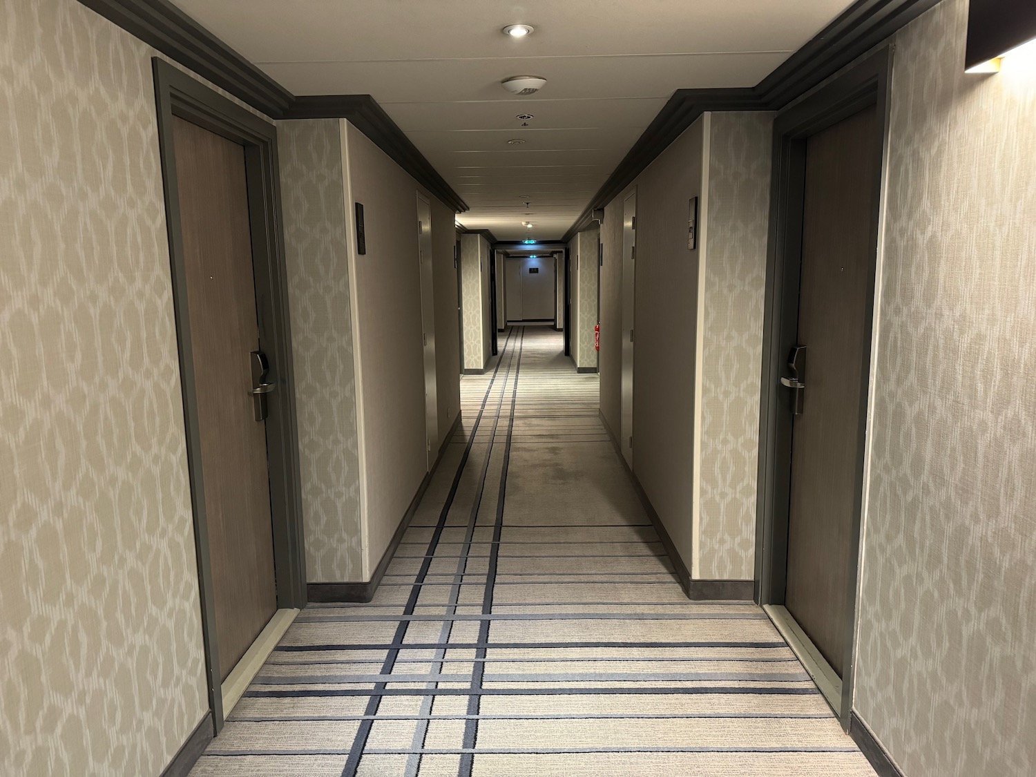 a hallway with doors and a striped carpet