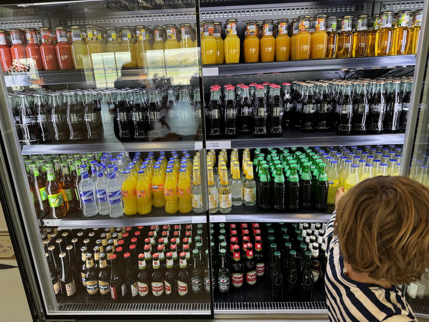 a woman looking at a shelf of beverages