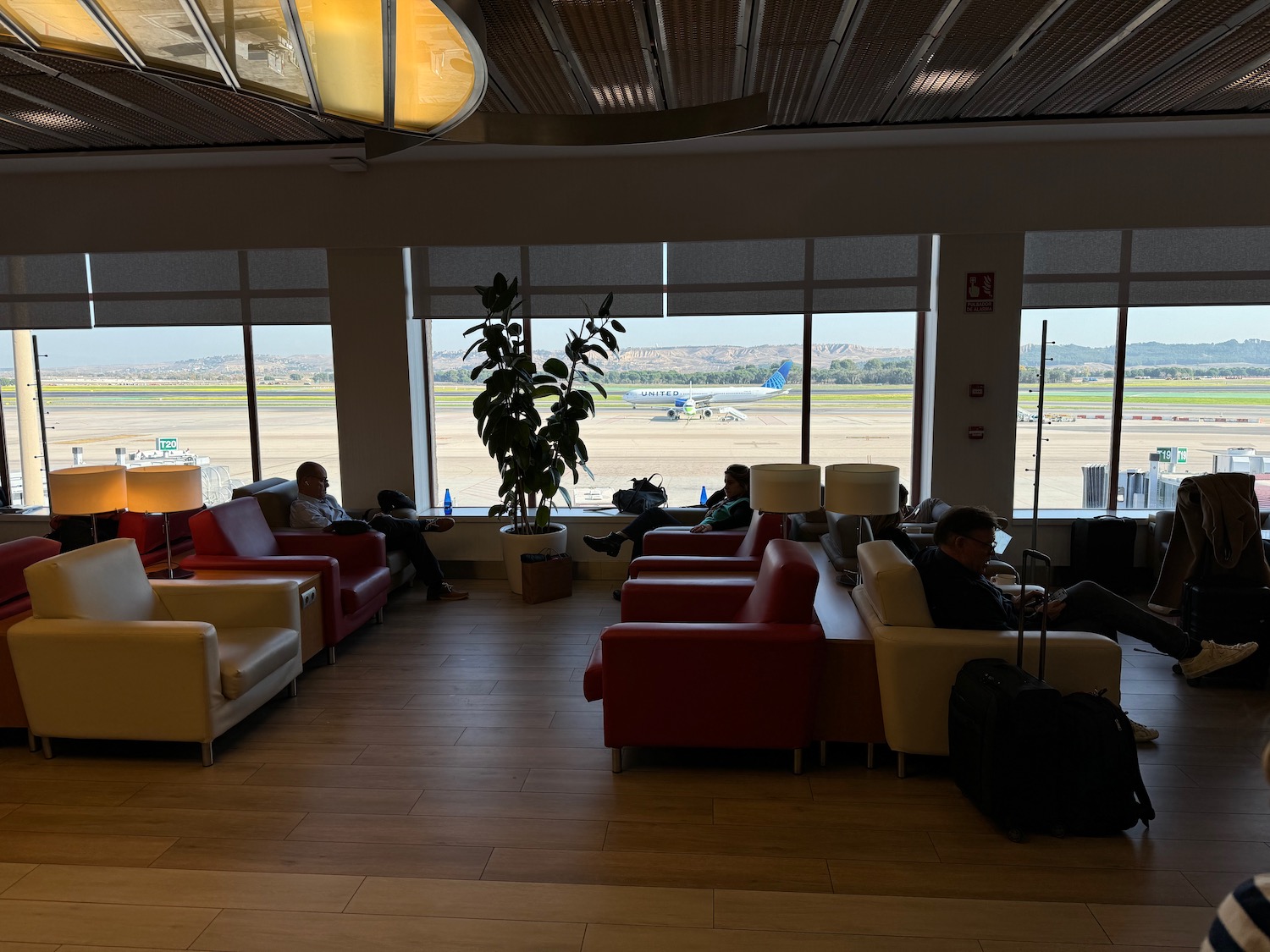 people sitting in a lounge area with a large window