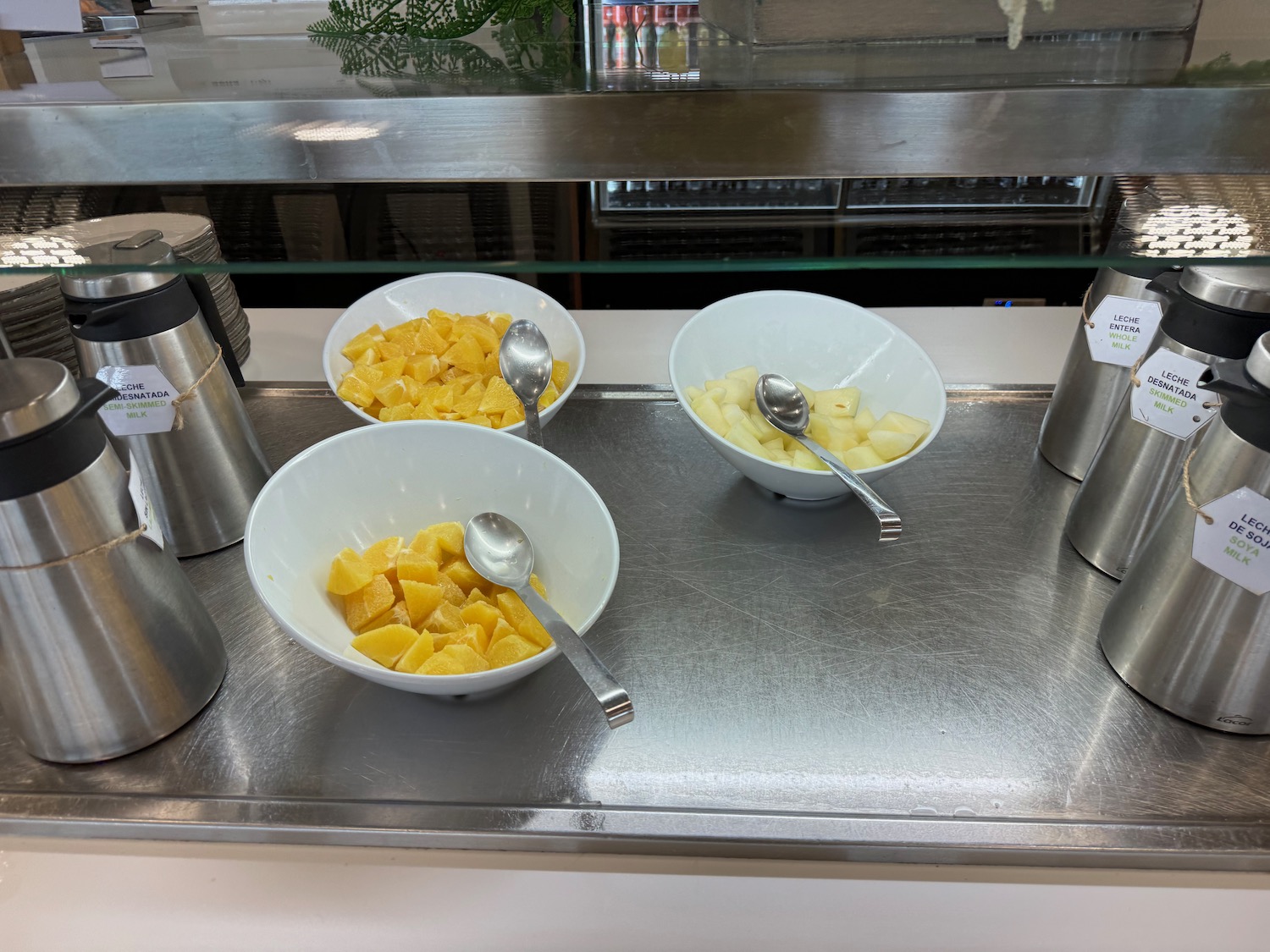 a group of bowls of fruit and spoons on a counter