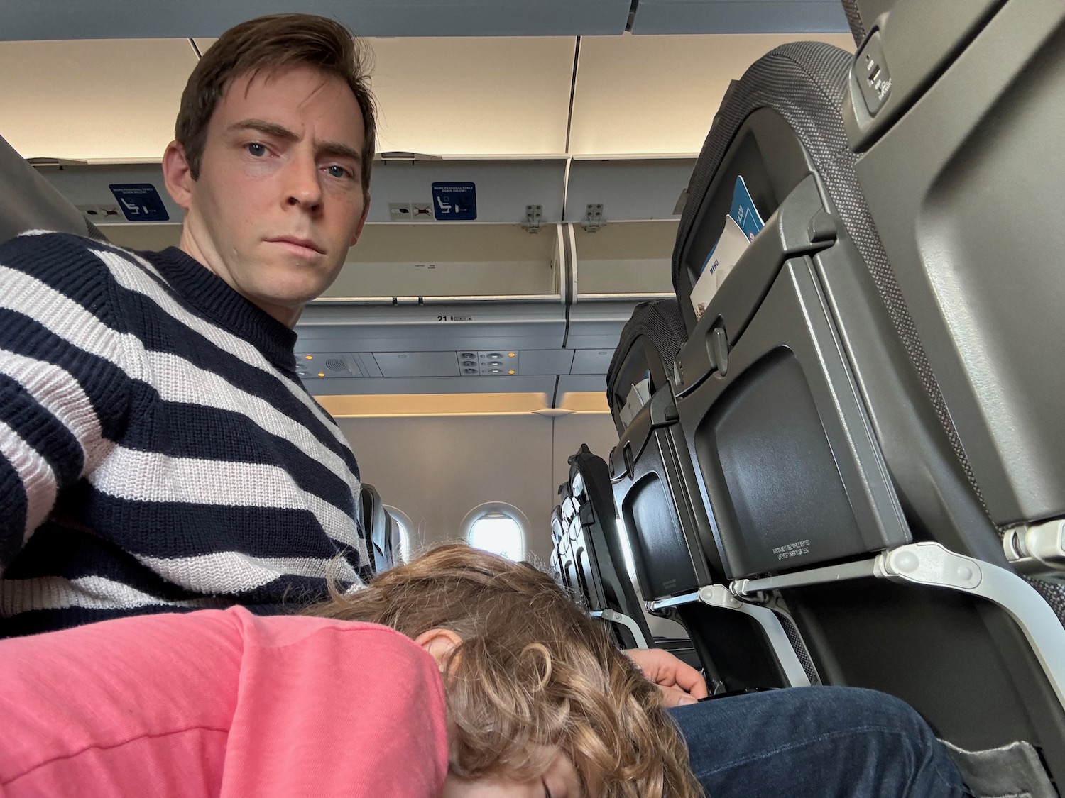 a man and child sleeping on an airplane