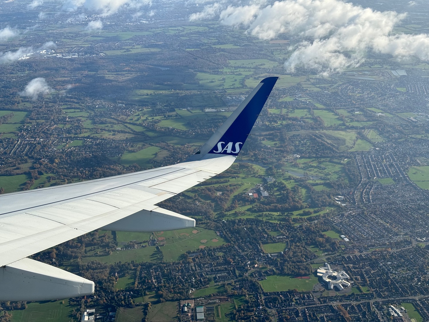 an airplane wing with a city in the background